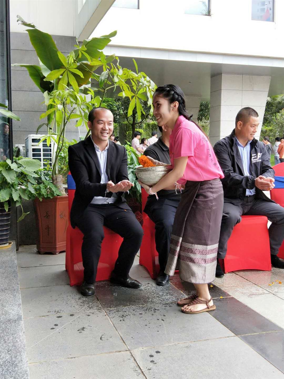 老撾駐廣西留學生代表將浸有花瓣的香水灑客人的手上，表示對嘉賓的美好祝福（圖一）