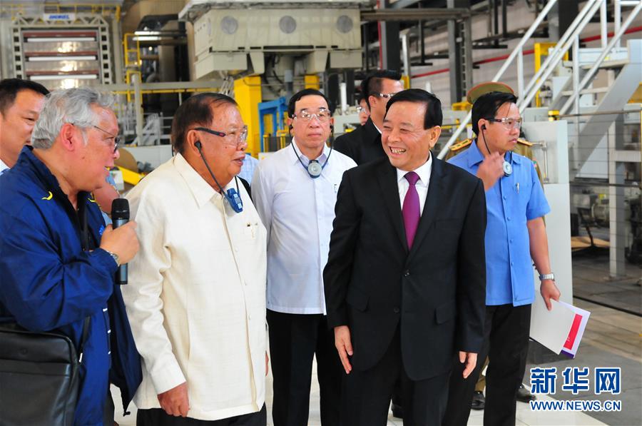 3月10日，在老撾沙灣拿吉省車邦縣，老撾人民革命黨中央總書記、國家主席本揚（左二）在山東太陽紙業(yè)股份有限公司董事長李洪信（右二）的陪同下視察公司。 新華社記者章建華攝